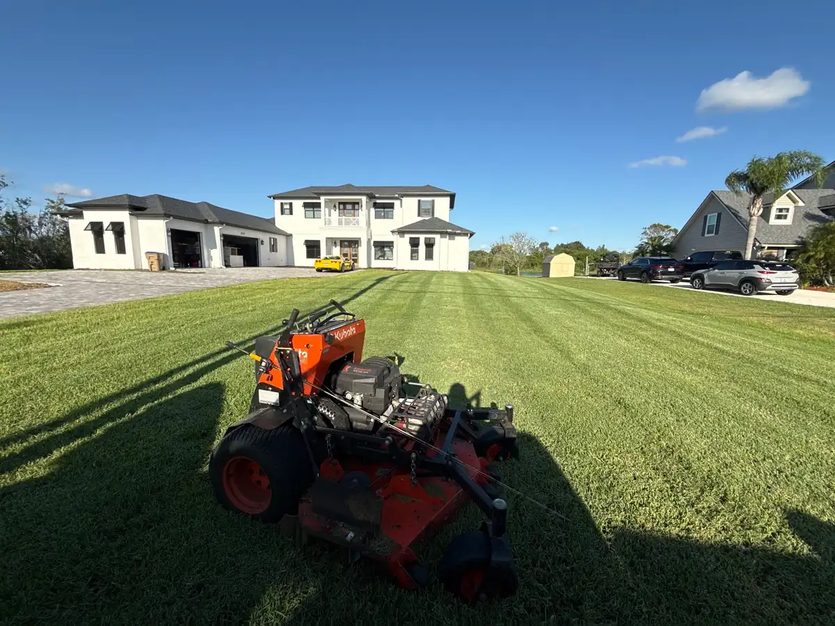 A stand-on mower on a freshly striped lawn