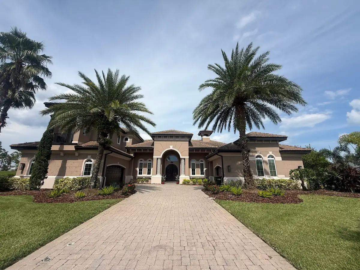 A long paver drive between two palms