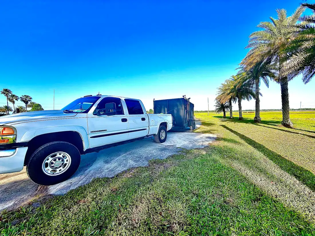The white work truck and trailer on a job